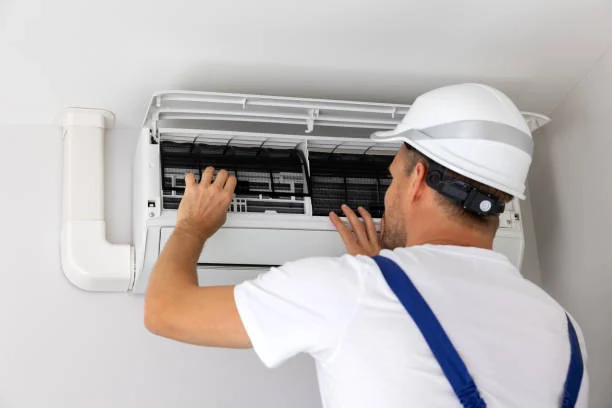 Technician inspecting the filters of a wall-mounted air conditioner