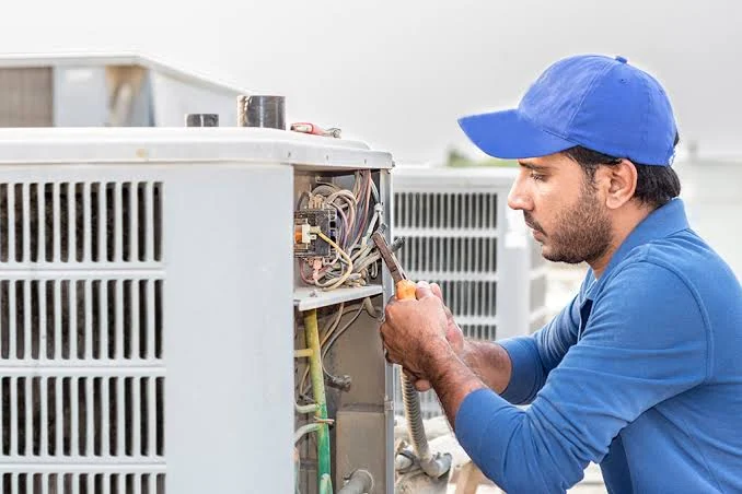 Technician repairing the wiring of an outdoor condenser unit
